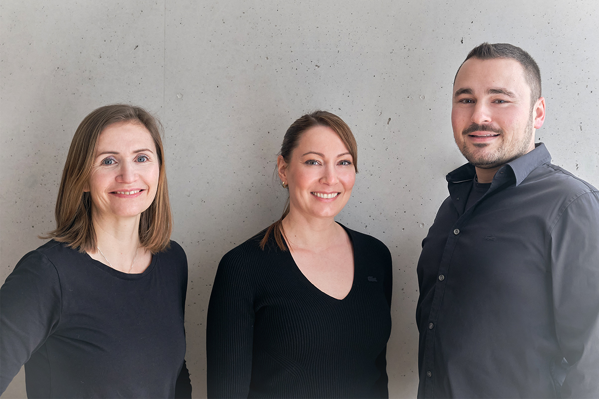 laub_muuhs architektur – teamfoto architekten drei architekten stehen gemeinsam vor betonwand